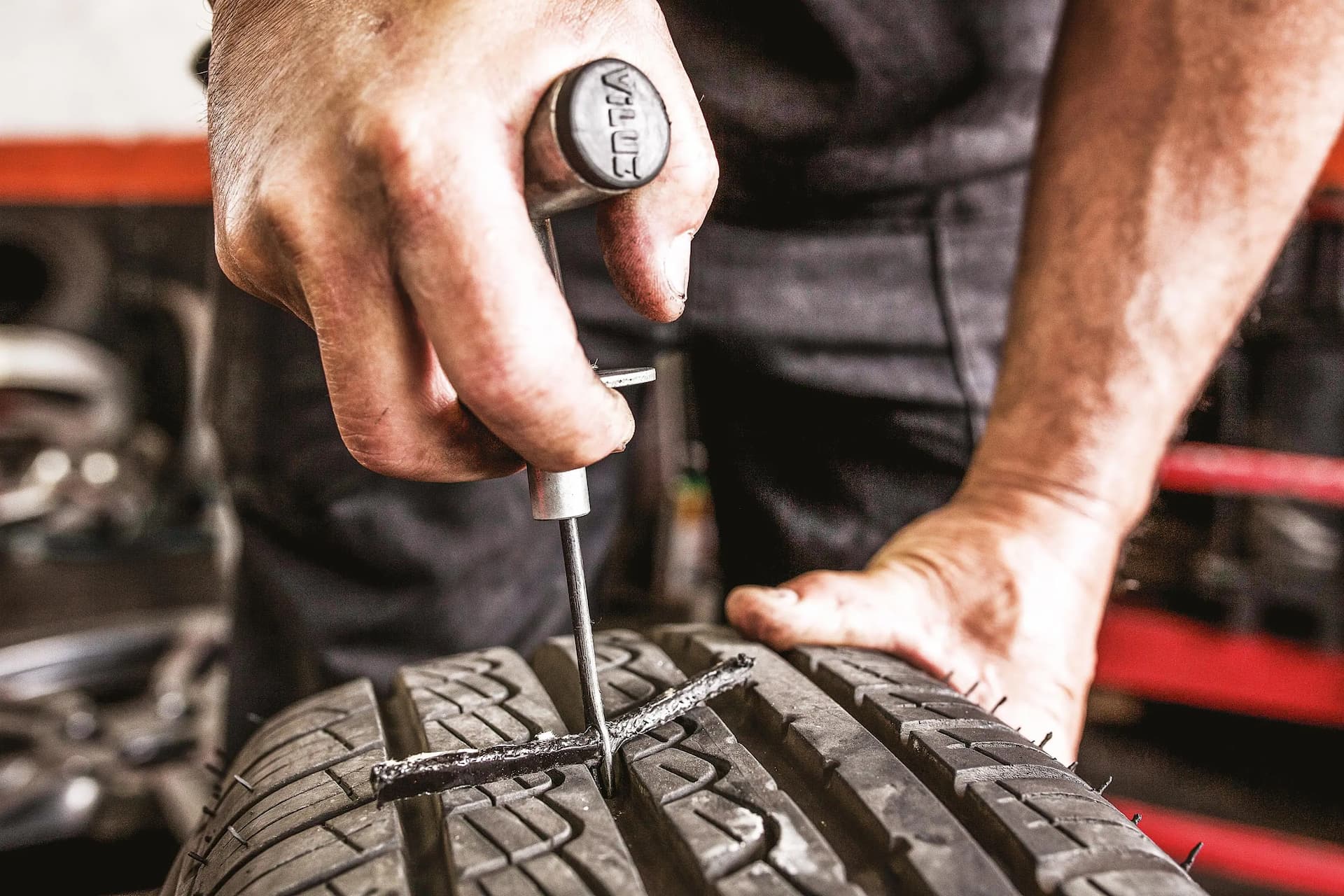 Mecânico da Mec 3 Centro Automotivo realizando conserto de pneu furado em Cajati.